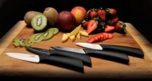 spread of paring knives near a fruit plate