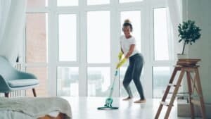someone using a steam mop to clean floor