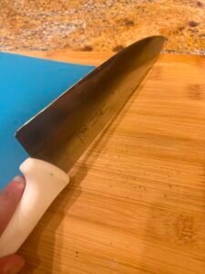 a knife scraping wood board with edge