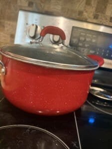 a dutch oven sitting on stove ready to go in oven