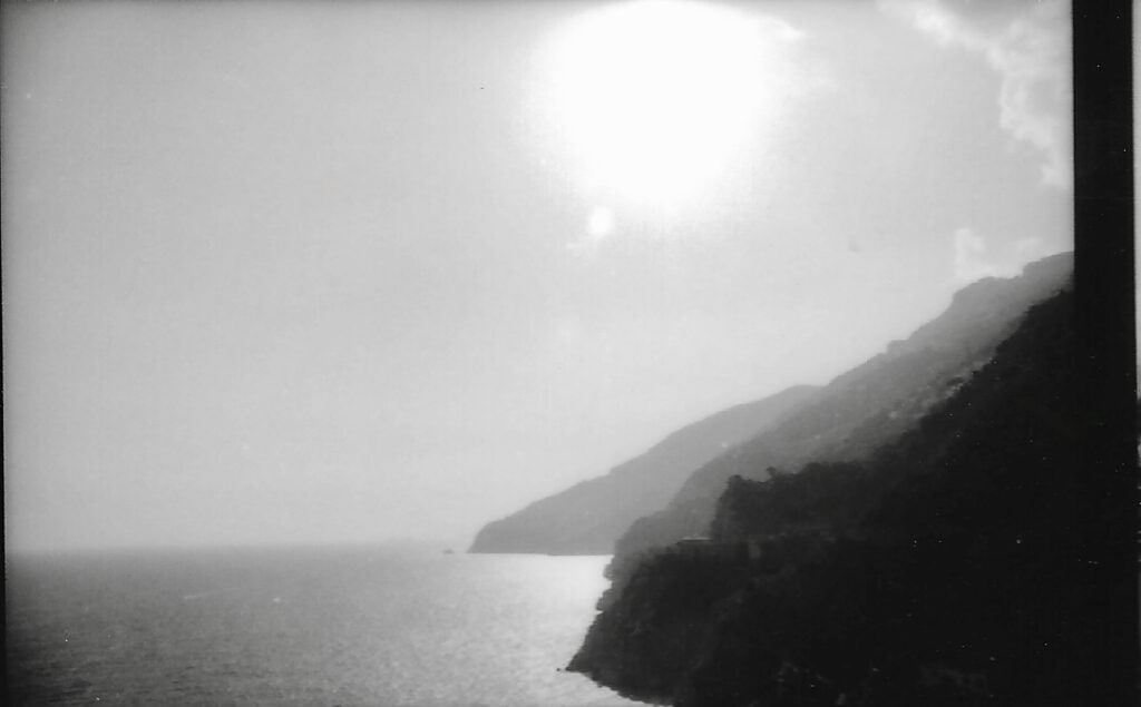 Scenic coastal view with cliffs and ocean under bright sky.