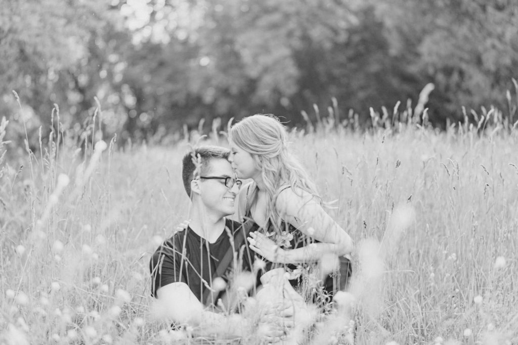 Sitting in Field -Cute Posing for Tall guys with short girls - Engagement Photo Poses- Posing close to Rideau Hall - Ideas for what to wear for Engagement Photography, Modern Engagement Session Inspiration Wardrobe Ideas. Unsure of what to wear for your engagement photos, we've got you! Romantic floral dress. Black Polo T-shirt & neutral pants . Boat Shoes and Fancy beaded wedges. Engagement downtown Ottawa. Grey Loft Studio is Ottawa's Wedding and Engagement Photographer Videographer for Real couples, showcasing photos that are modern, bright, and fun. Photographe Gatineau