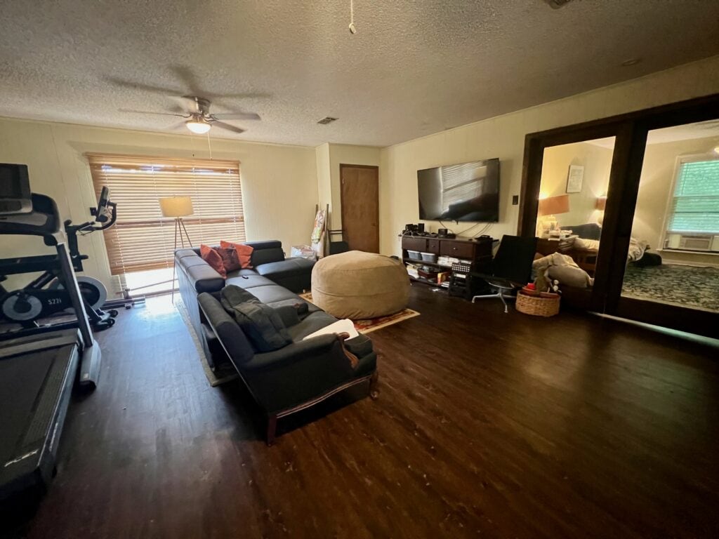 Spacious living room with modern furniture and workout equipment.