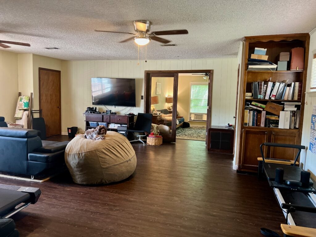 Cozy living room with TV, bookshelf, and bean bag chair for relaxation.