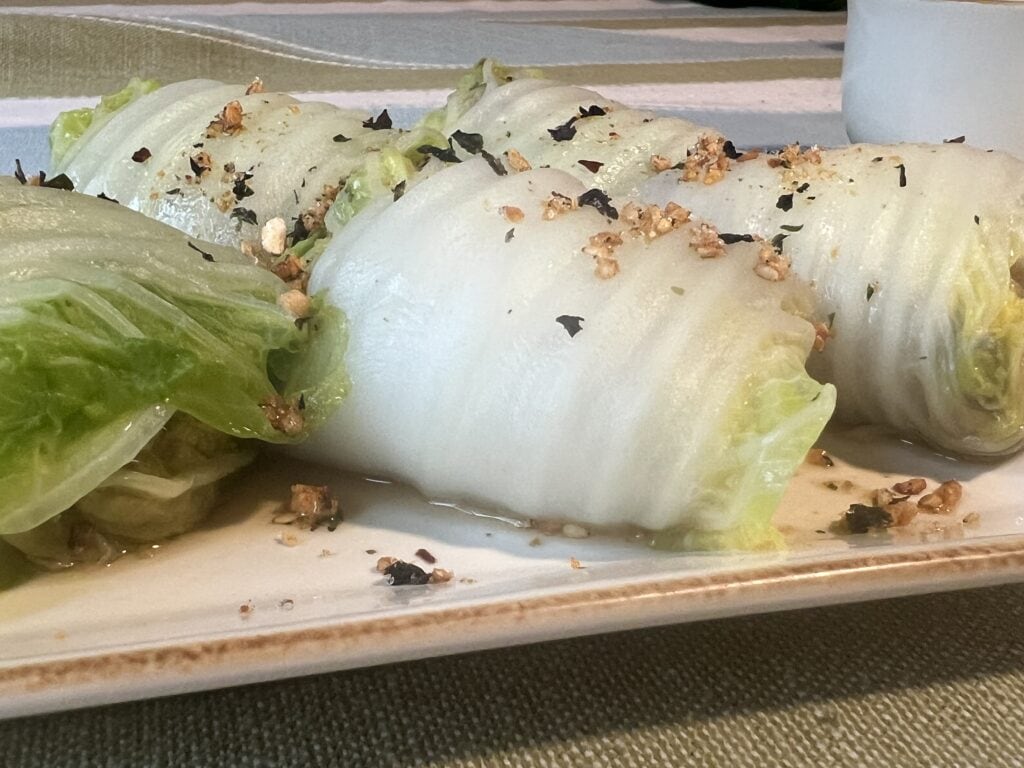 Lettuce wraps with herbs and nuts on a white plate at Redcypress Designs.