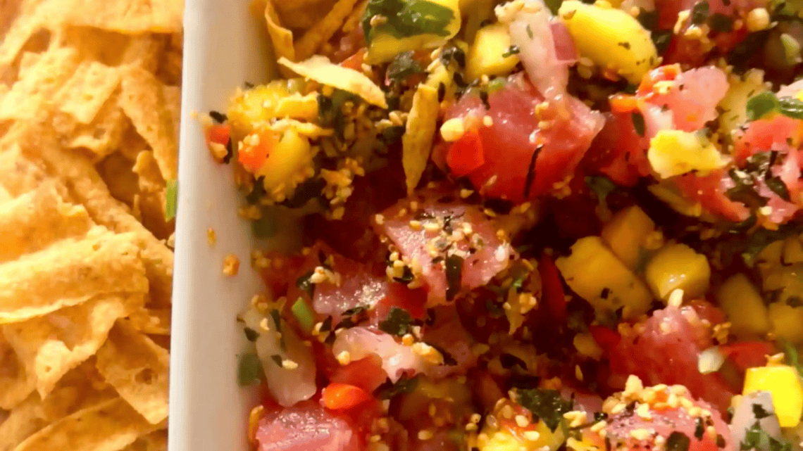 Colorful mango poke nachos with fresh vegetables and herbs.