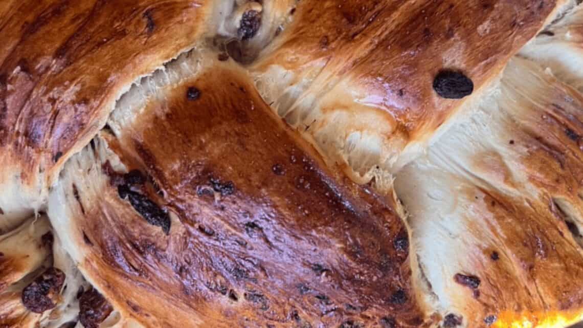 Freshly baked holiday bread with a golden crust and dried fruit accents.