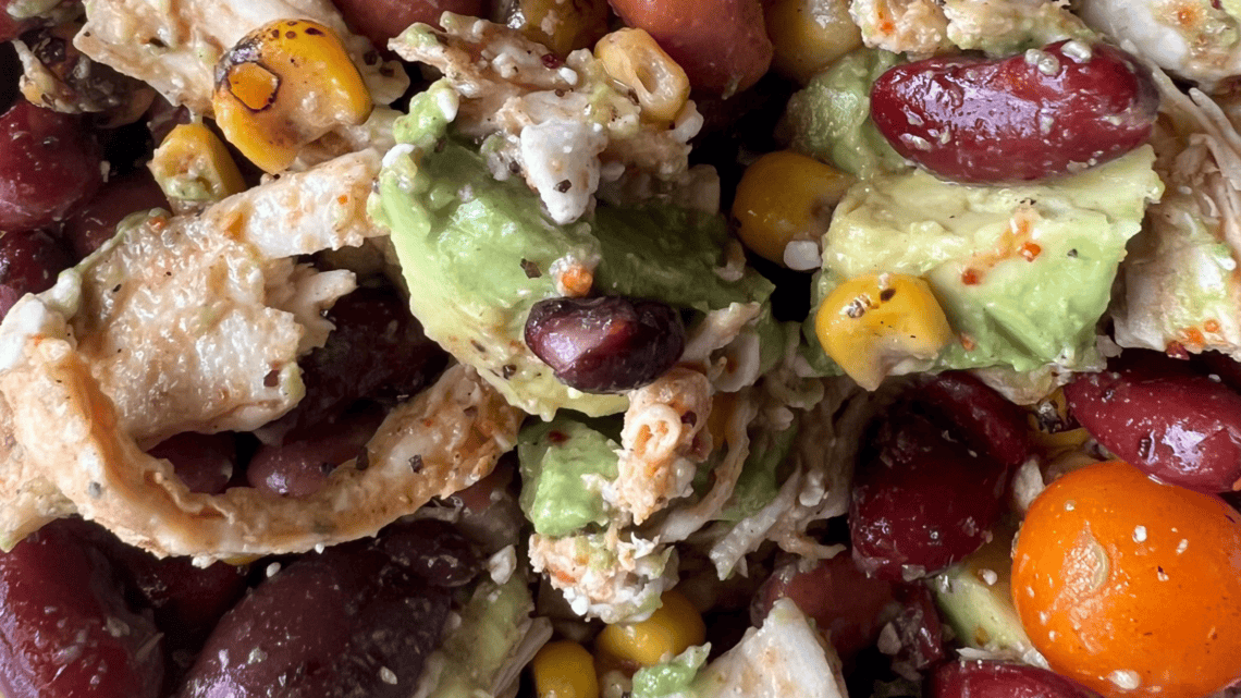 Healthy protein-packed lunch with beans, avocado, corn, and vegetables.
