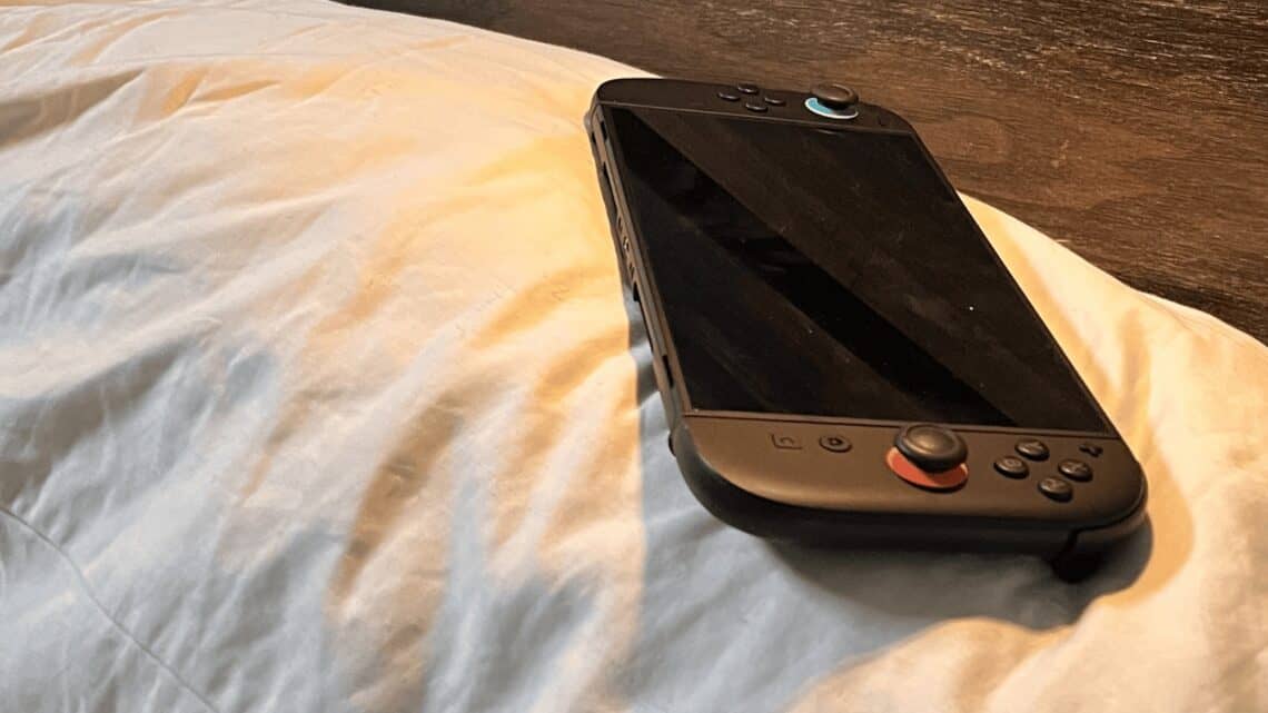Handheld gaming console on a bed for cozy night-in gaming sessions.