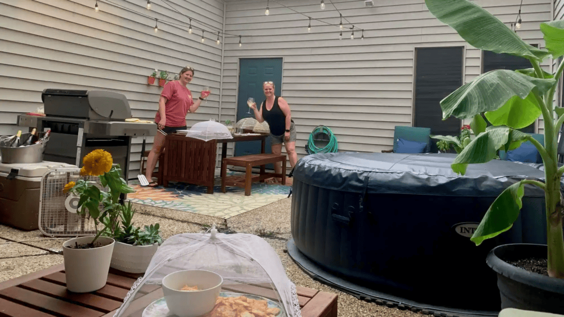 Family enjoying outdoor space with hot tub and seating area.