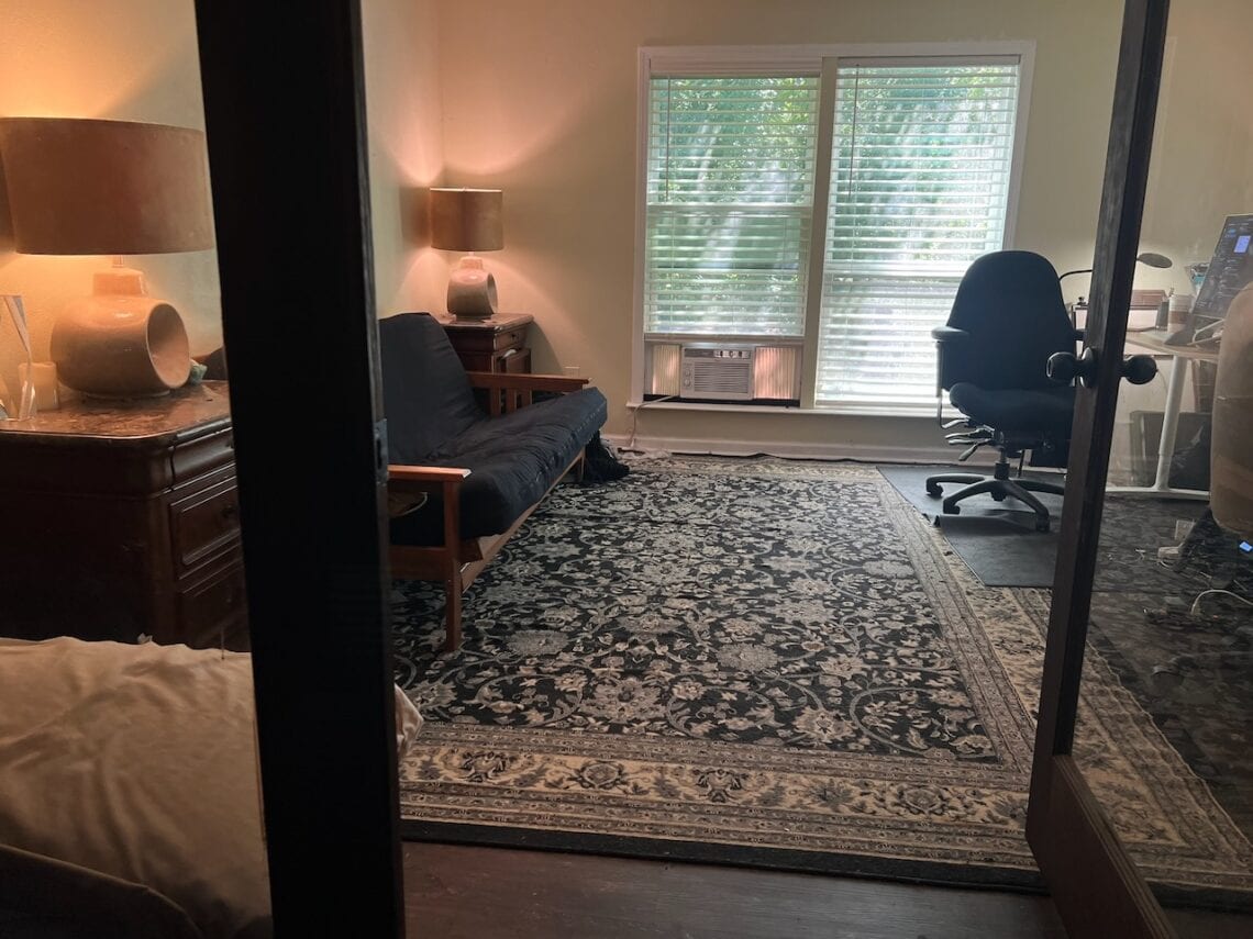 Cozy home office with a black desk, office chair, and window view.
