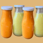 Fresh fall juice bottles with orange and green smoothies for cozy season.