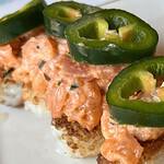 Delicious crispy rice bites topped with spicy salmon and jalapeño slices, perfect for quick sushi sn.