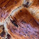 Freshly baked holiday bread with a golden crust and dried fruit accents.