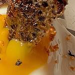 Gourmet breakfast with fried egg, crispy bacon, and toast, showcasing delicious food presentation.