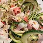 Fresh zucchini noodles with crab meat and spices for a healthy dish.