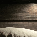 Woman using FSA-eligible tools for a calming night routine in a cozy bedroom.