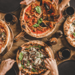 Delicious pizza, pasta, tacos, and sushi enjoyed during a cozy home food night. Perfect for sharing.