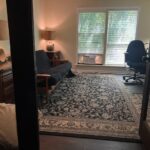Cozy home office with a black desk, office chair, and window view.