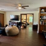 Cozy living room with TV, bookshelf, and bean bag chair for relaxation.