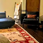 Cozy living room with sectional sofa, armchair, and decorative rug.