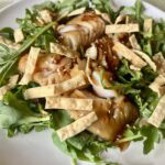 Miso-marinated black cod served over baby arugula with sweet chili sauce, sesame seeds, and crispy wonton strips.
