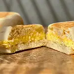 Close-up of a breakfast sandwich with egg and melted cheese.