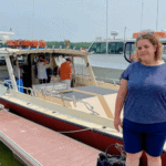 Woman enjoying a day at the marina with boats in the background.
