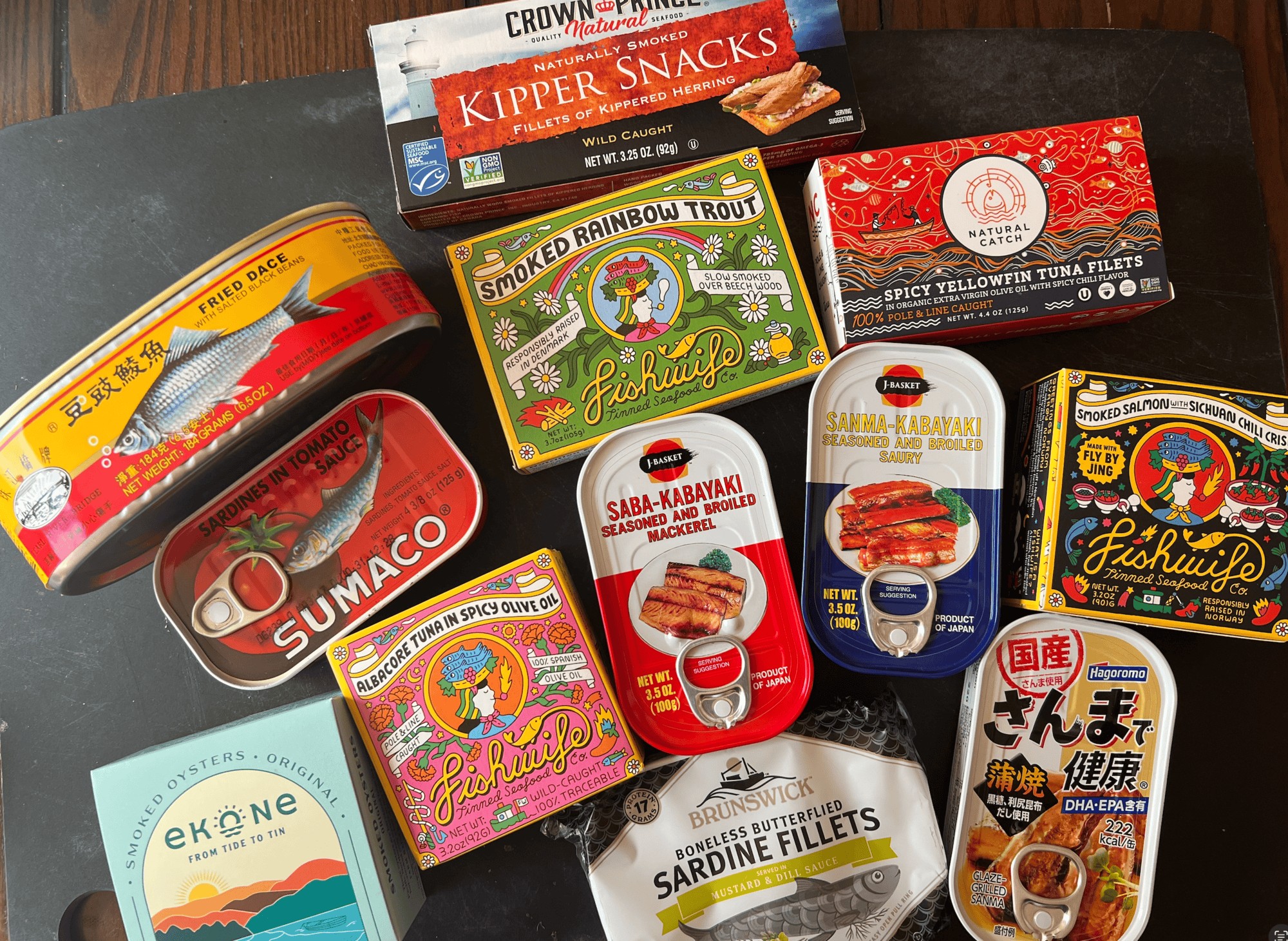 Assorted tinned fish products including sardines, mackerel, and tuna for healthy capsule lunches. Pe.