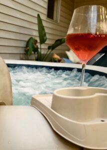 Glass of rosé wine and hot tub for relaxation and leisure.