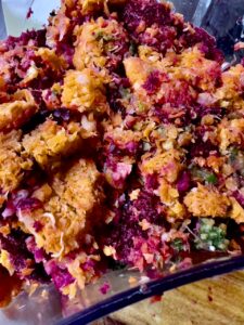 A close-up of vibrant, multicolored juice pulp made from beets, carrots, greens, and other fruits and vegetables after juicing.