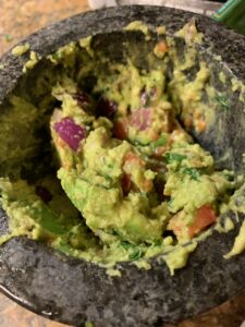 Close-up of freshly made guacamole in a traditional molcajete bowl.