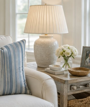 Cozy living room with a white ceramic table lamp and floral decor.