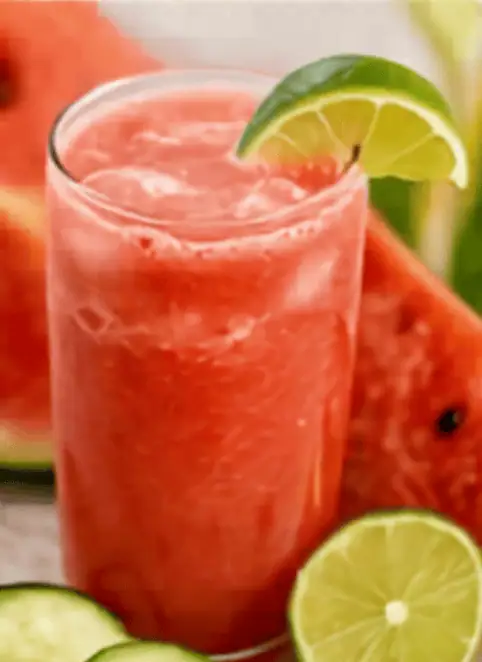 Cold watermelon lime smoothie with lime wedge garnish.