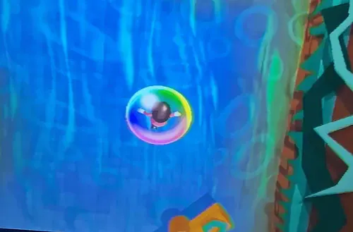 Vibrant bubble floating in a digital game environment with blue and green hues.
