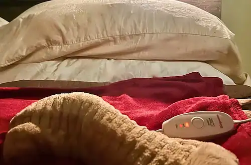 Heated blanket on bed with pillows for a warm, cozy bedroom atmosphere.