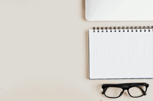 Notepad, glasses, and laptop on desk for FSA eligible items planning.