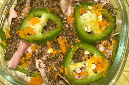 Close-up of jalapeño slices topped with fish roe and chopped nuts.