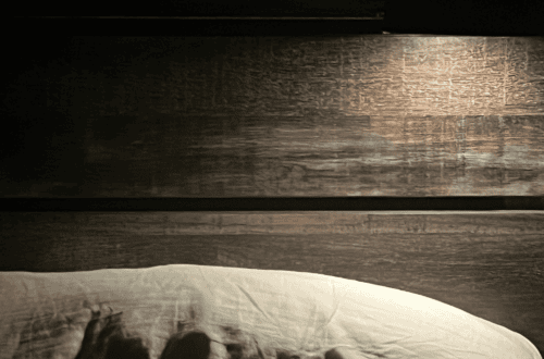 Woman using FSA-eligible tools for a calming night routine in a cozy bedroom.