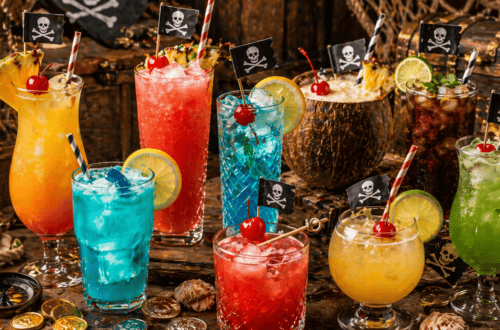 Colorful tropical cocktails with pirate flags for themed party drinks.