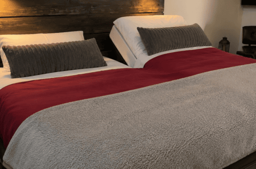 Split King adjustable bed with red and gray bedding and pillows.