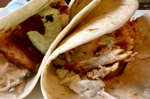Close-up of blackened mahi mahi tacos with mango slaw and cilantro sauce.