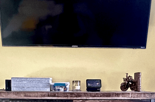 Modern home decor setup with TV and decorative items on wooden shelf.
