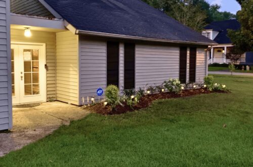 Contemporary house exterior with well-maintained lawn and garden.