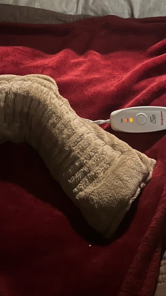 Heated blanket and thermometer on cozy red bedspread.