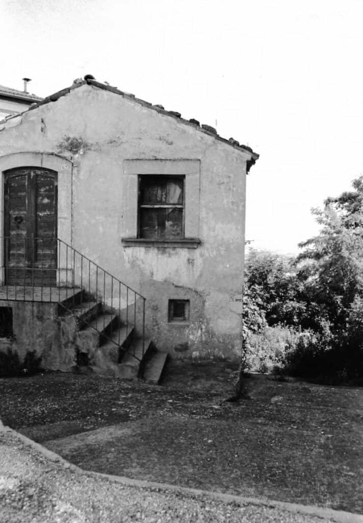 Old house with stairs and window, black and white photo.