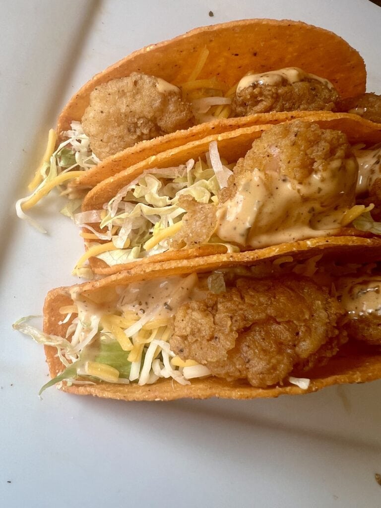 Fresh fish tacos with crispy batter, shredded cabbage, and creamy sauce in warm corn tortillas.