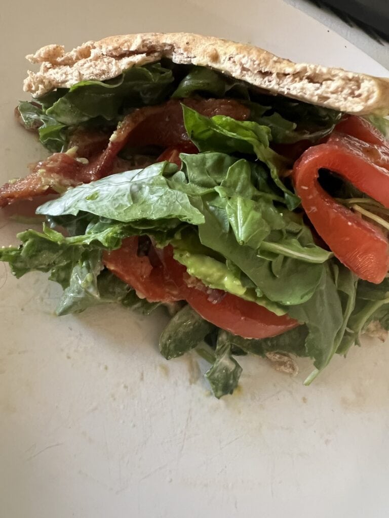 Close-up of a veggie sandwich with lettuce, tomato, and whole grain bread.