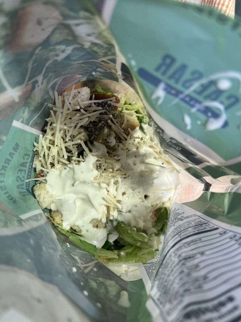 Close-up of a fresh salad wrap with vegetables and dressing.