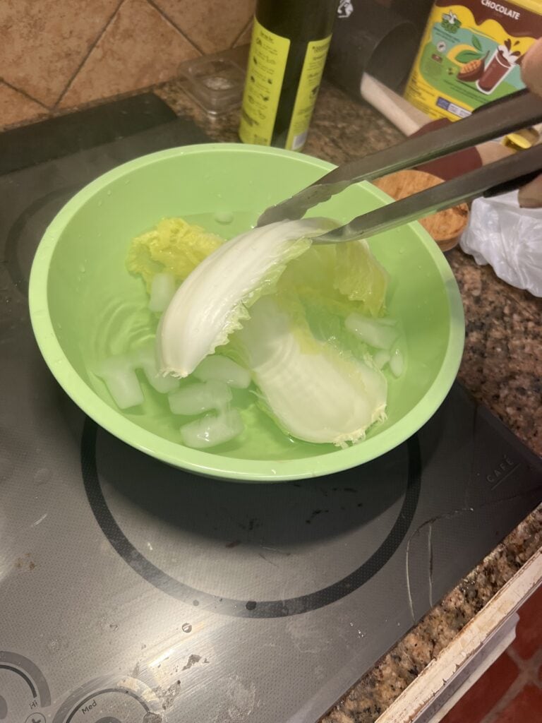 Cream being scooped into a green bowl for homemade ice cream.